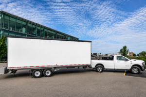 Alt text: SL100 mobile stage trailer transported by ATH Productions